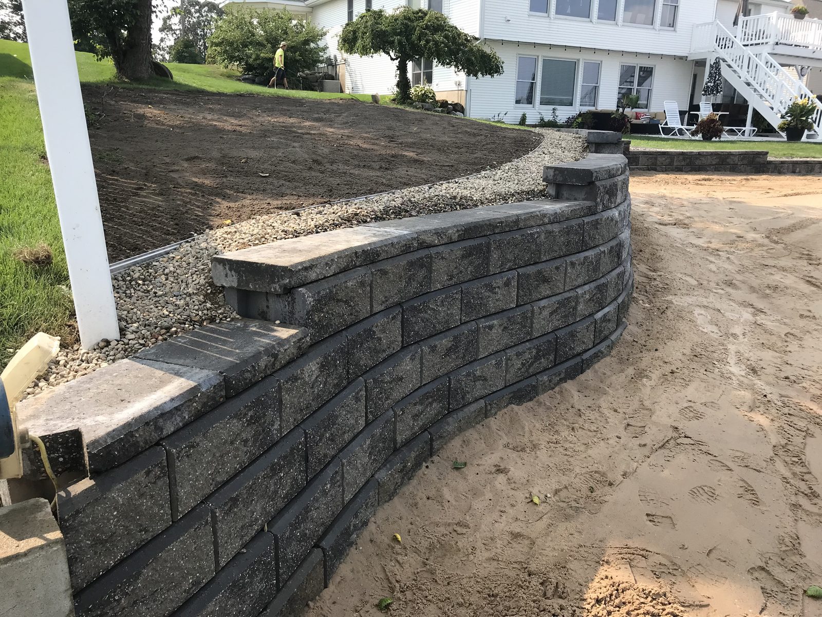 Charcoal block retaining wall and integrated steps installed at a West Michigan home