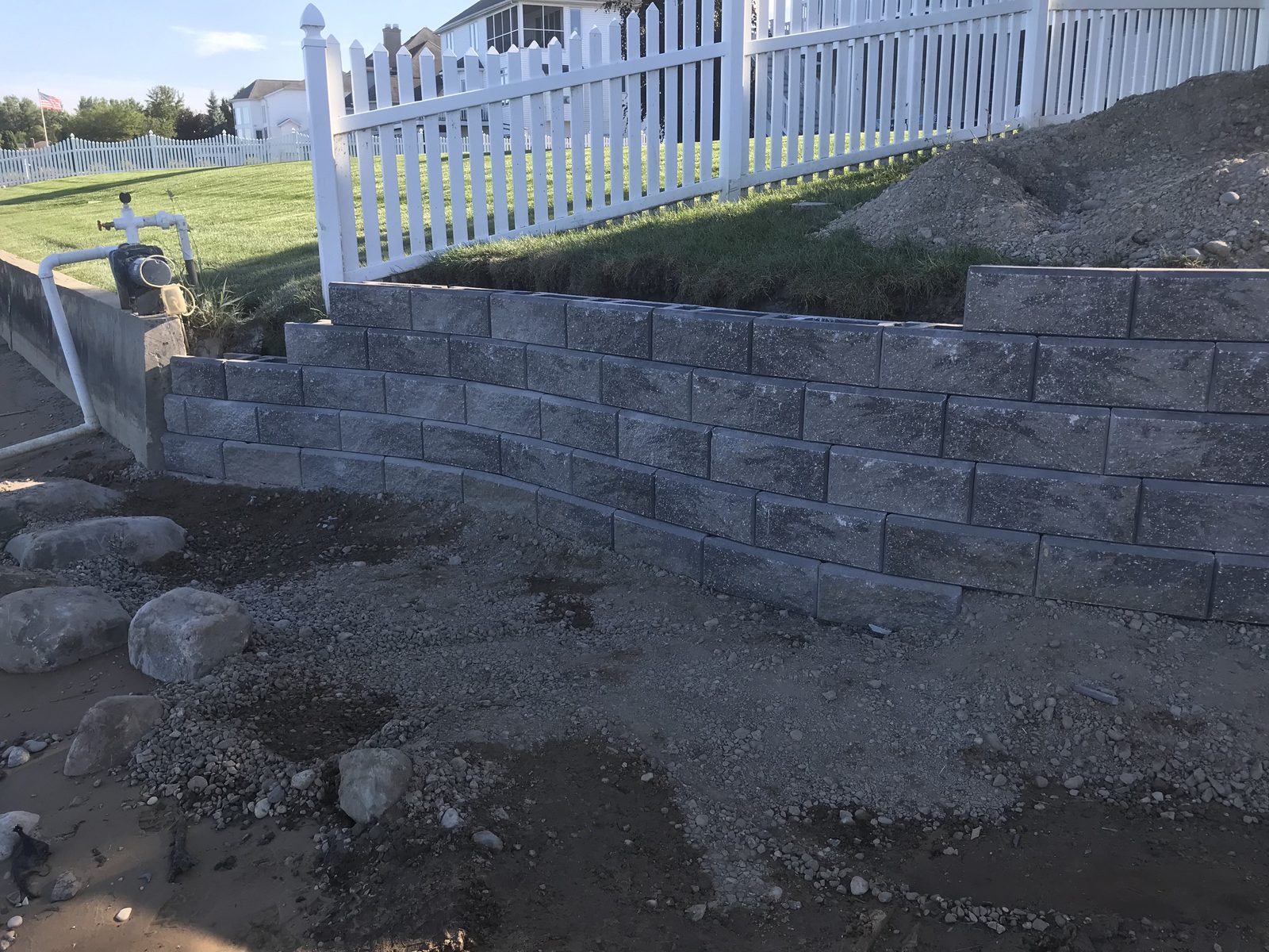 Curved gray block retaining wall installed at a West Michigan property