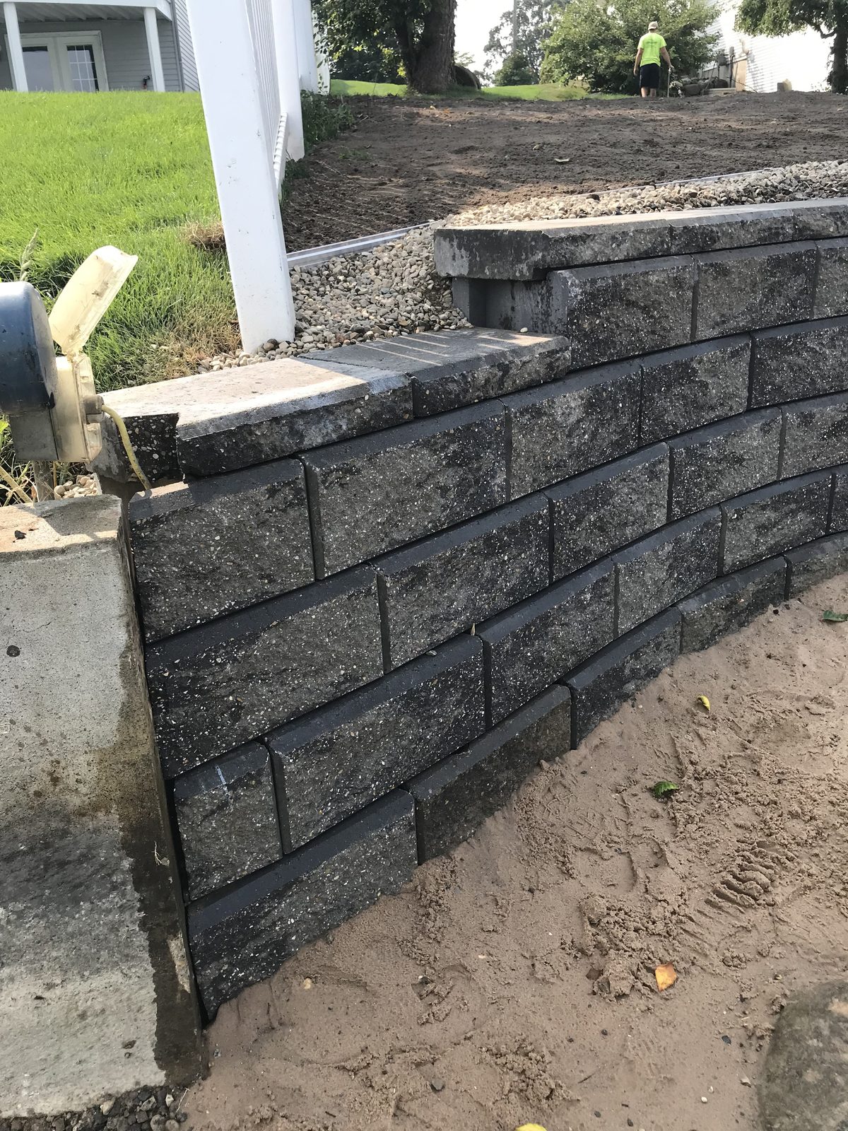 Detail of charcoal stacked-stone retaining wall corner in West Michigan